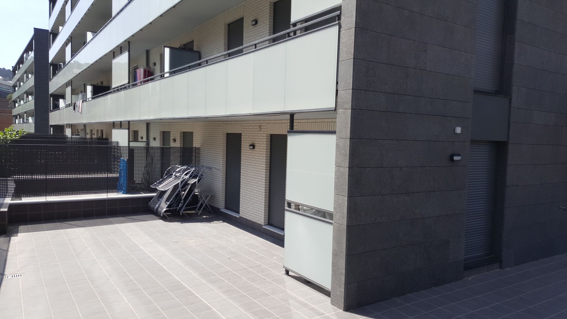 Un edificio con muchos balcones y una terraza de madera.