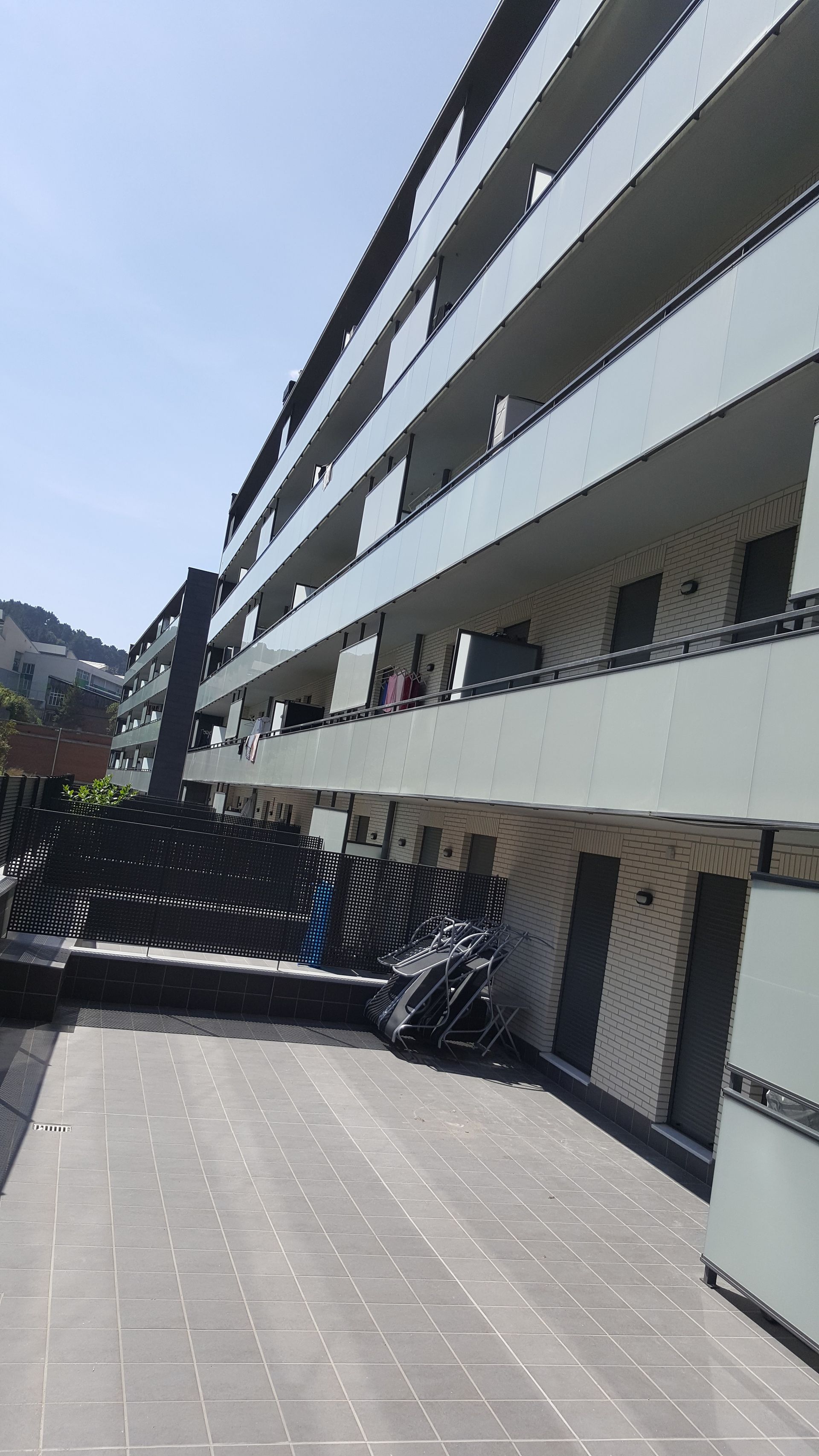 Un gran edificio de apartamentos con muchos balcones en un día soleado.
