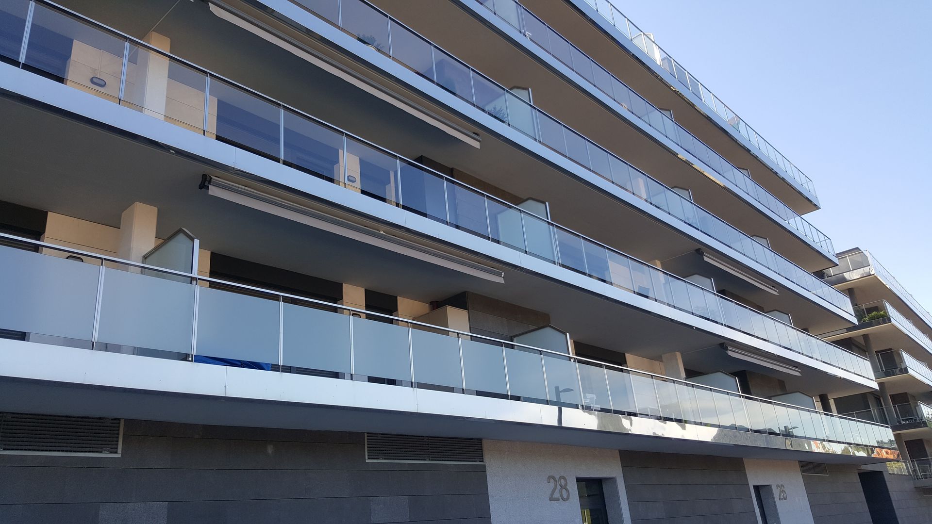 Un edificio con muchos balcones y un cielo azul al fondo.