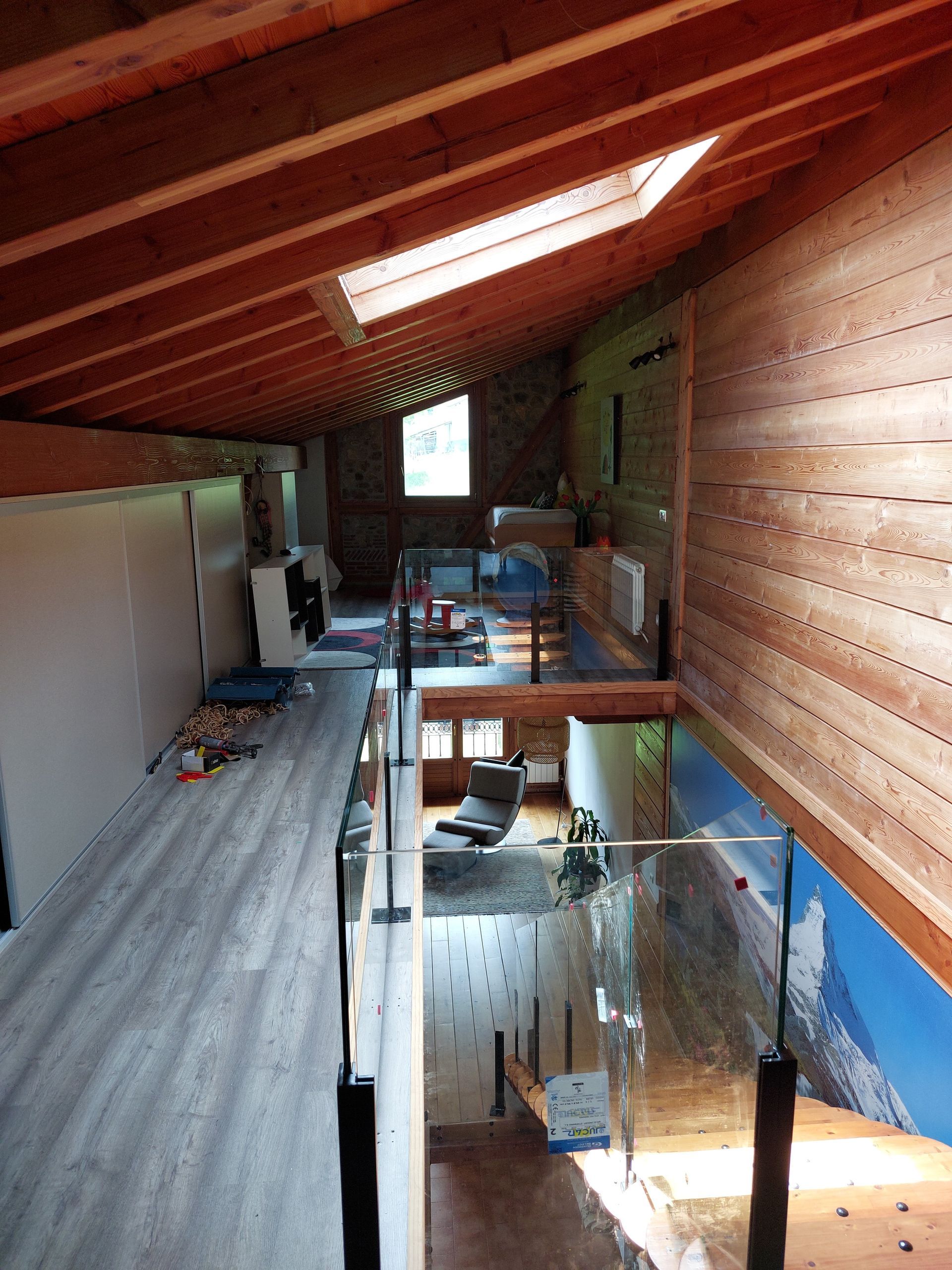 Una habitación con una escalera y un tragaluz en el techo.