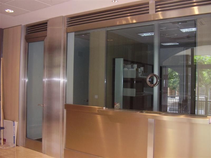 Una habitación con una pared de acero inoxidable y una puerta de vidrio
