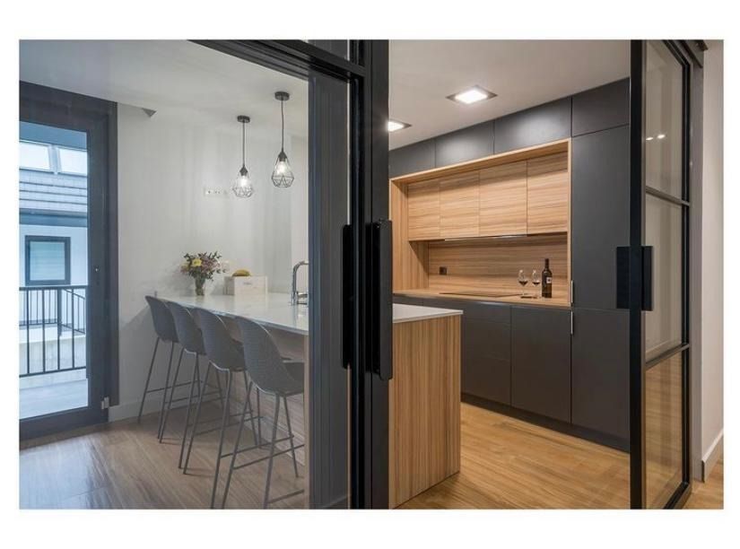 Una cocina con una puerta corrediza de vidrio que conduce a un balcón.