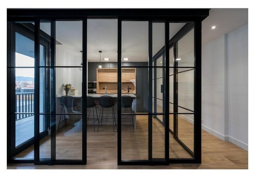 Una cocina con puertas corredizas de vidrio entre el comedor y la cocina.