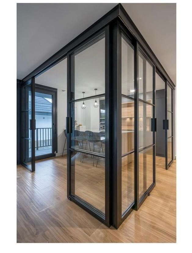 Una habitación con muchas puertas de vidrio y piso de madera.