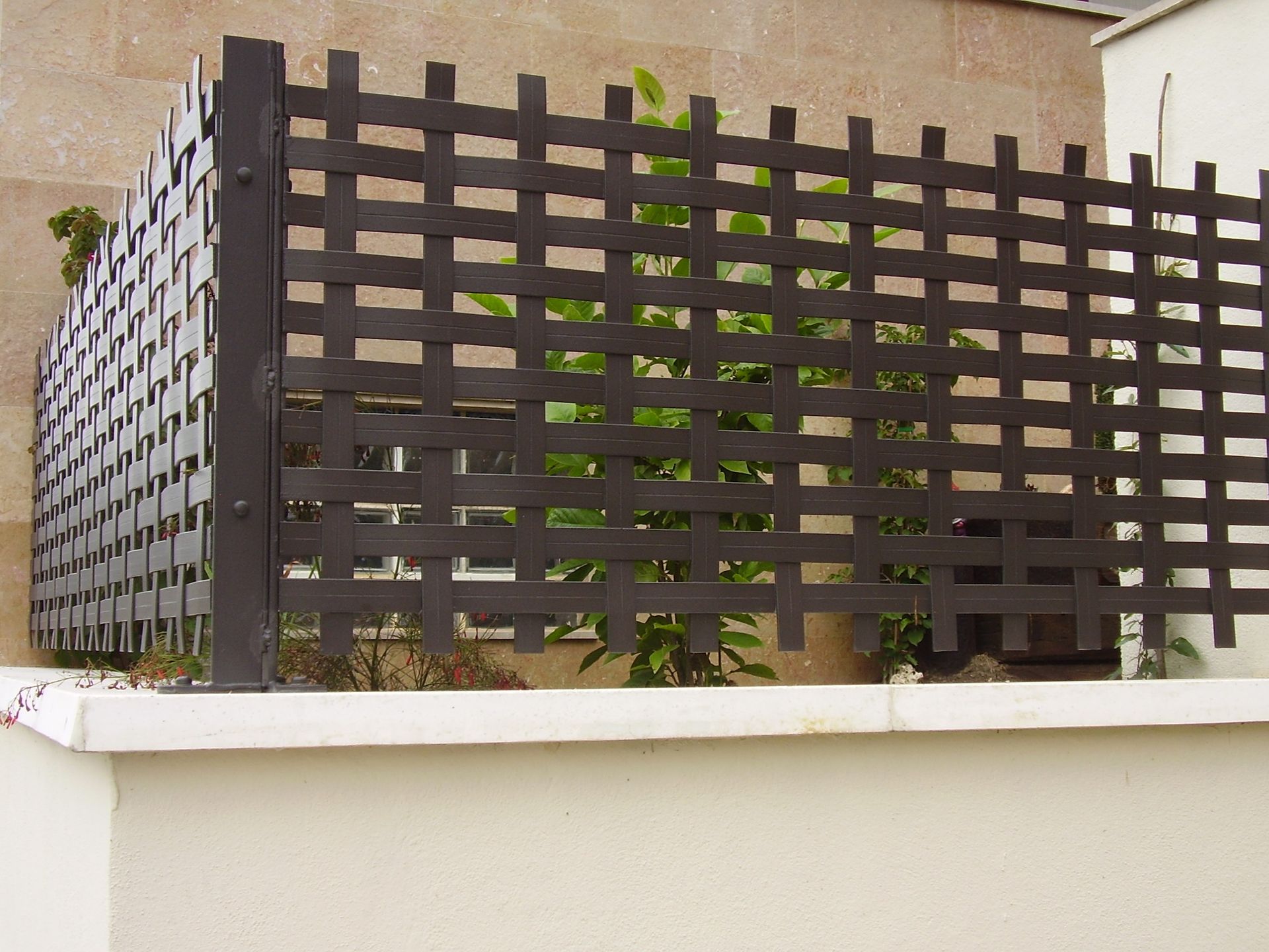 Una valla de madera con una pared blanca detrás.