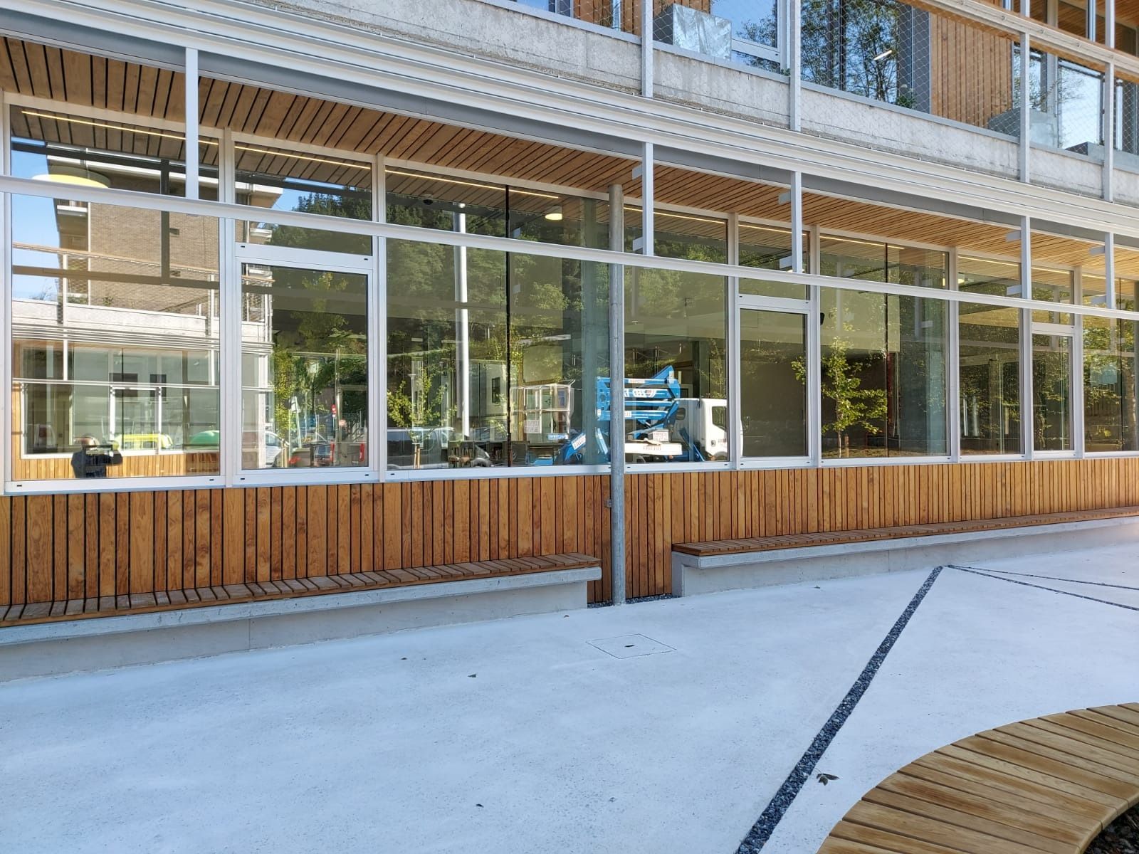 Un edificio grande con muchas ventanas y una valla de madera.