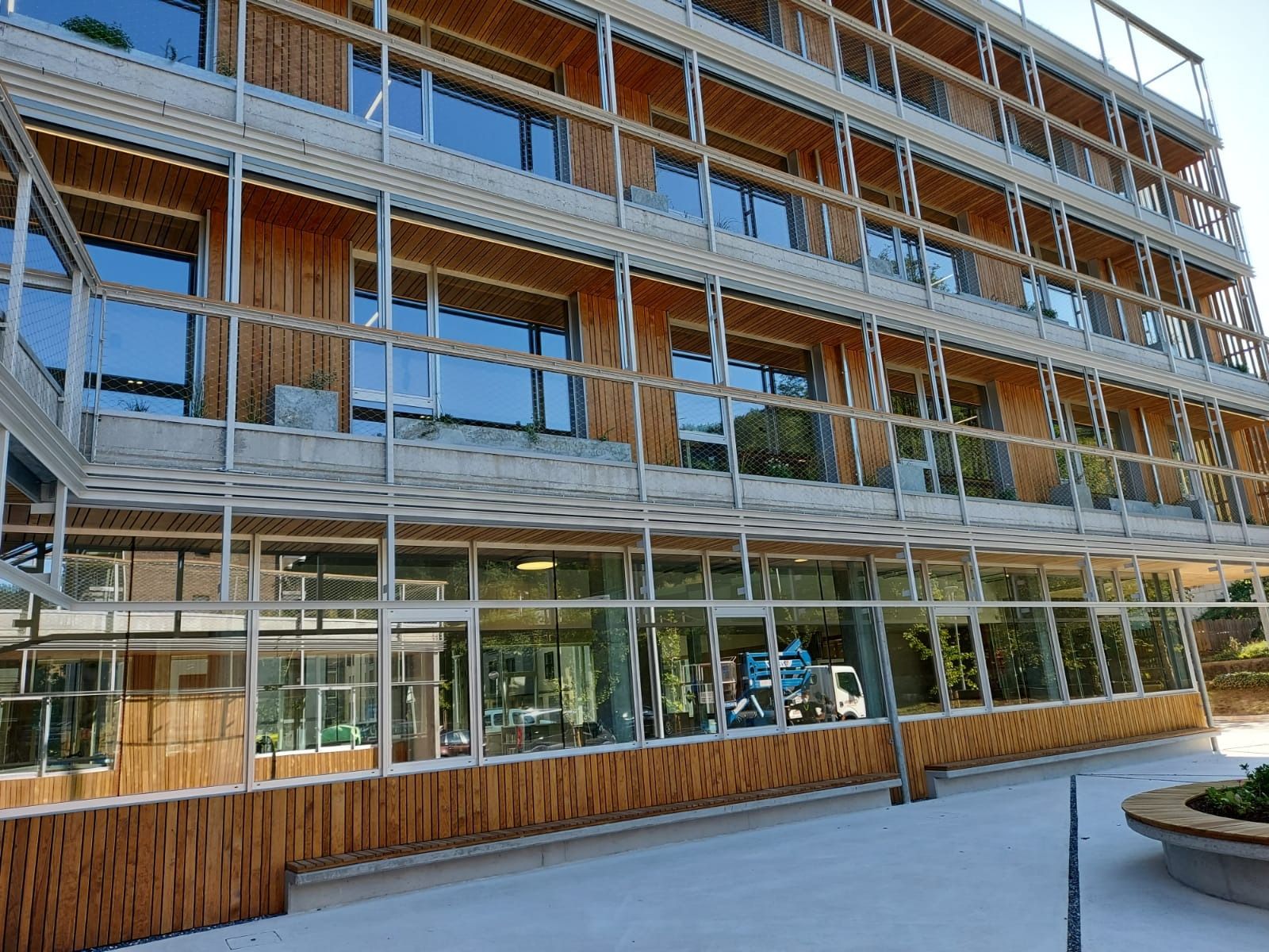 Un edificio grande con muchas ventanas y una fachada de madera.