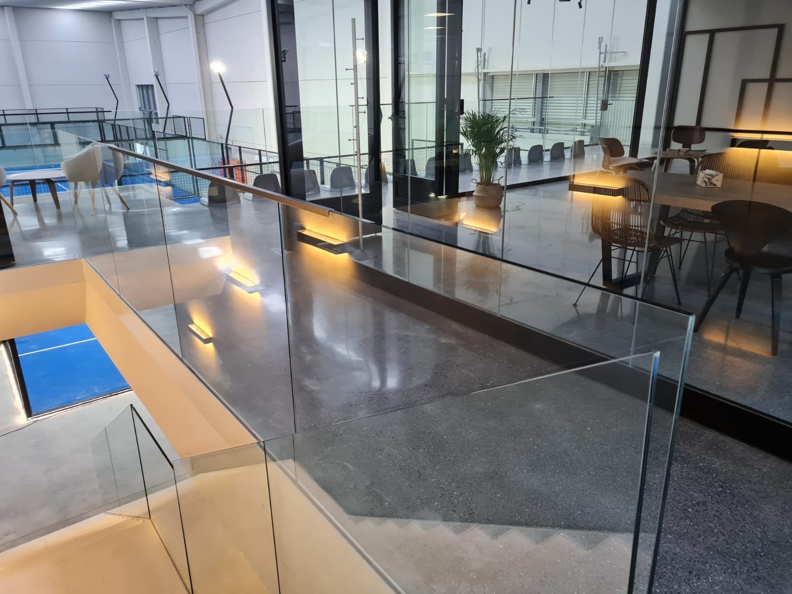 Una escalera con barandilla de cristal en un edificio