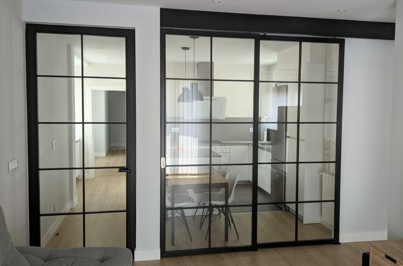 Una sala de estar con puertas corredizas de vidrio que conducen a una cocina.