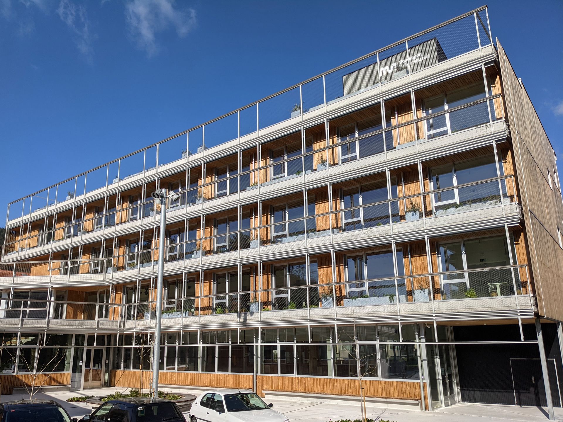 Se está construyendo un gran edificio con muchas ventanas y balcones.