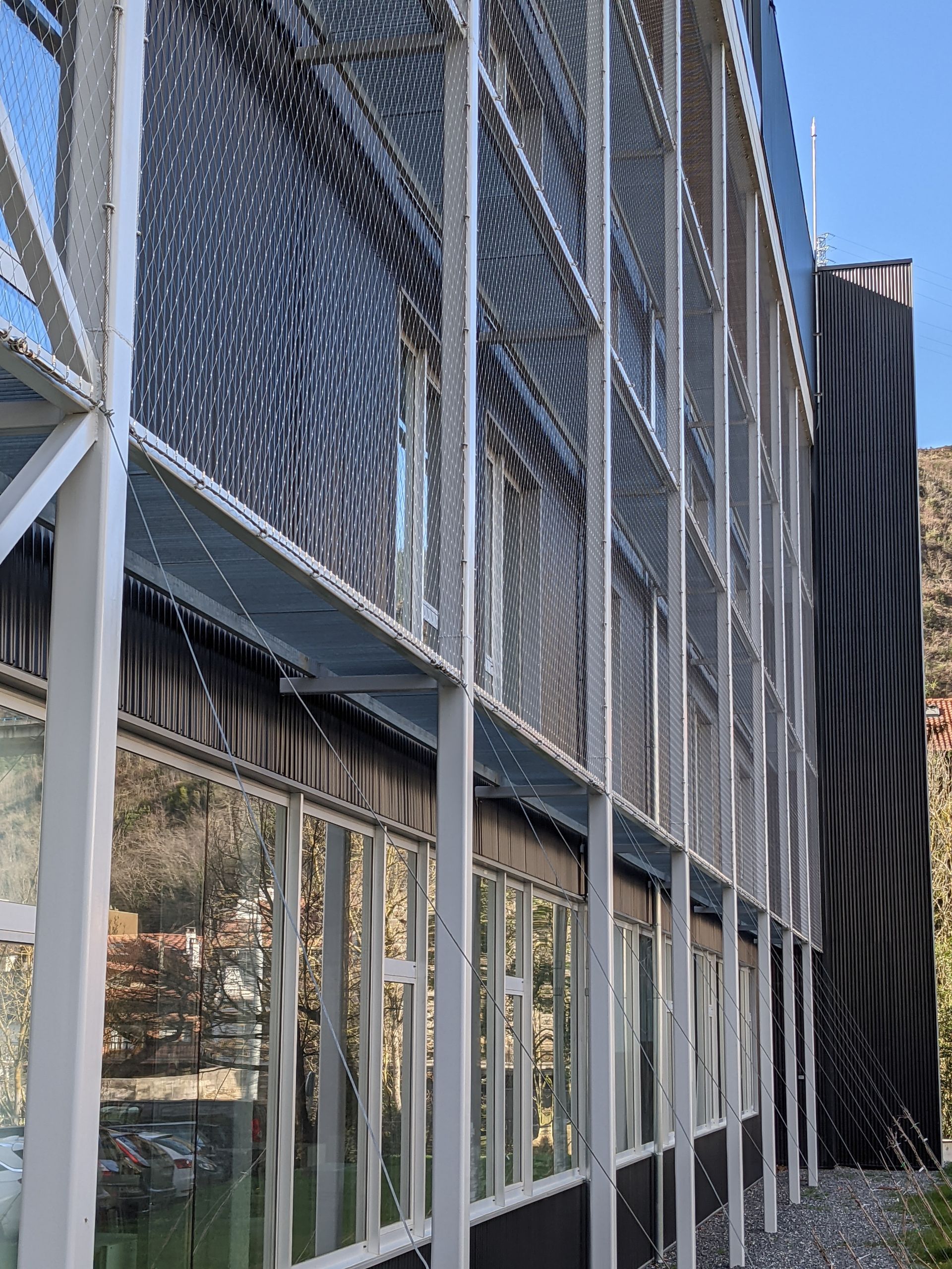 Un edificio con muchas ventanas y una valla a su alrededor.