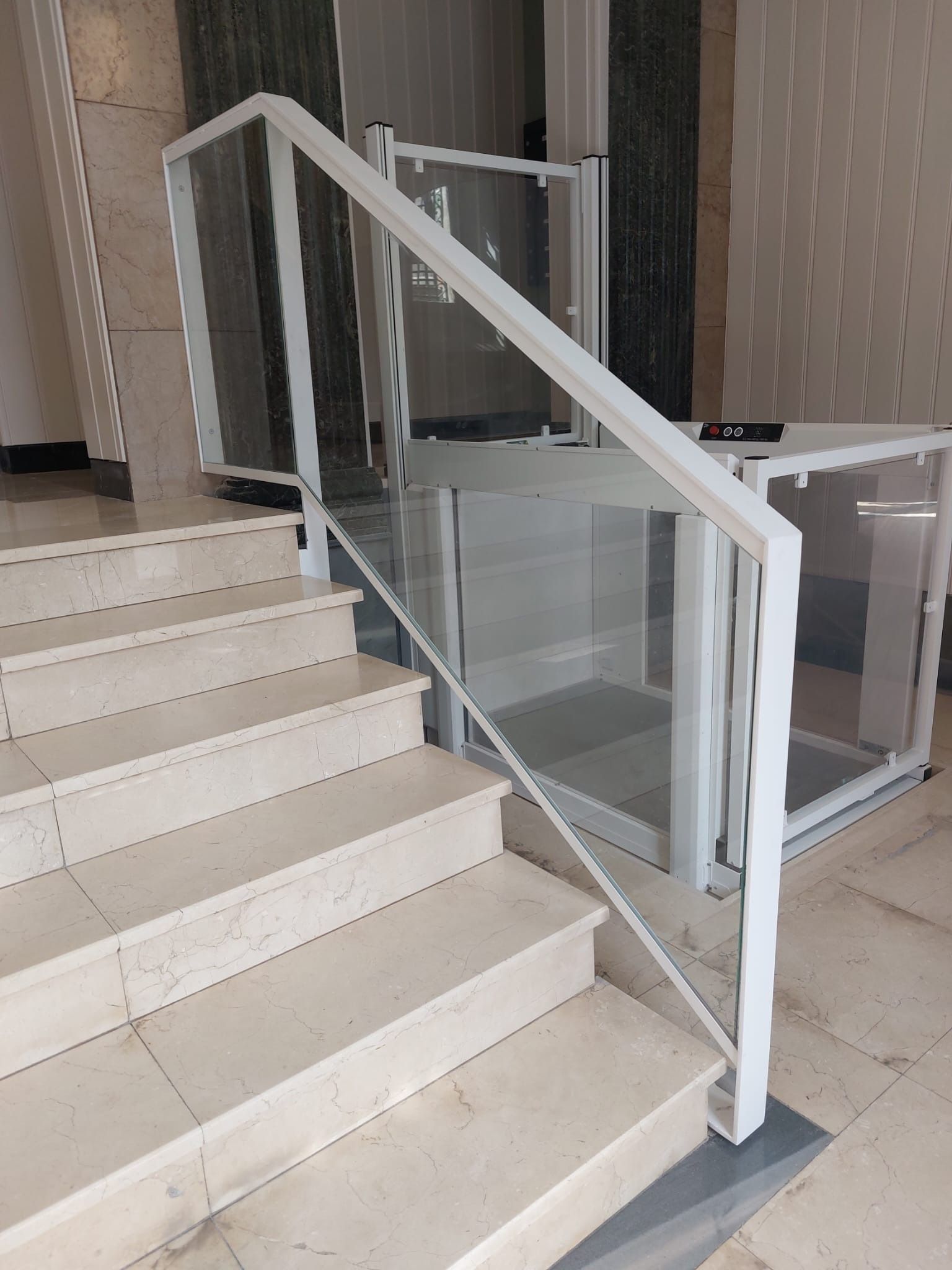 Una escalera con barandilla blanca y barandilla de cristal.