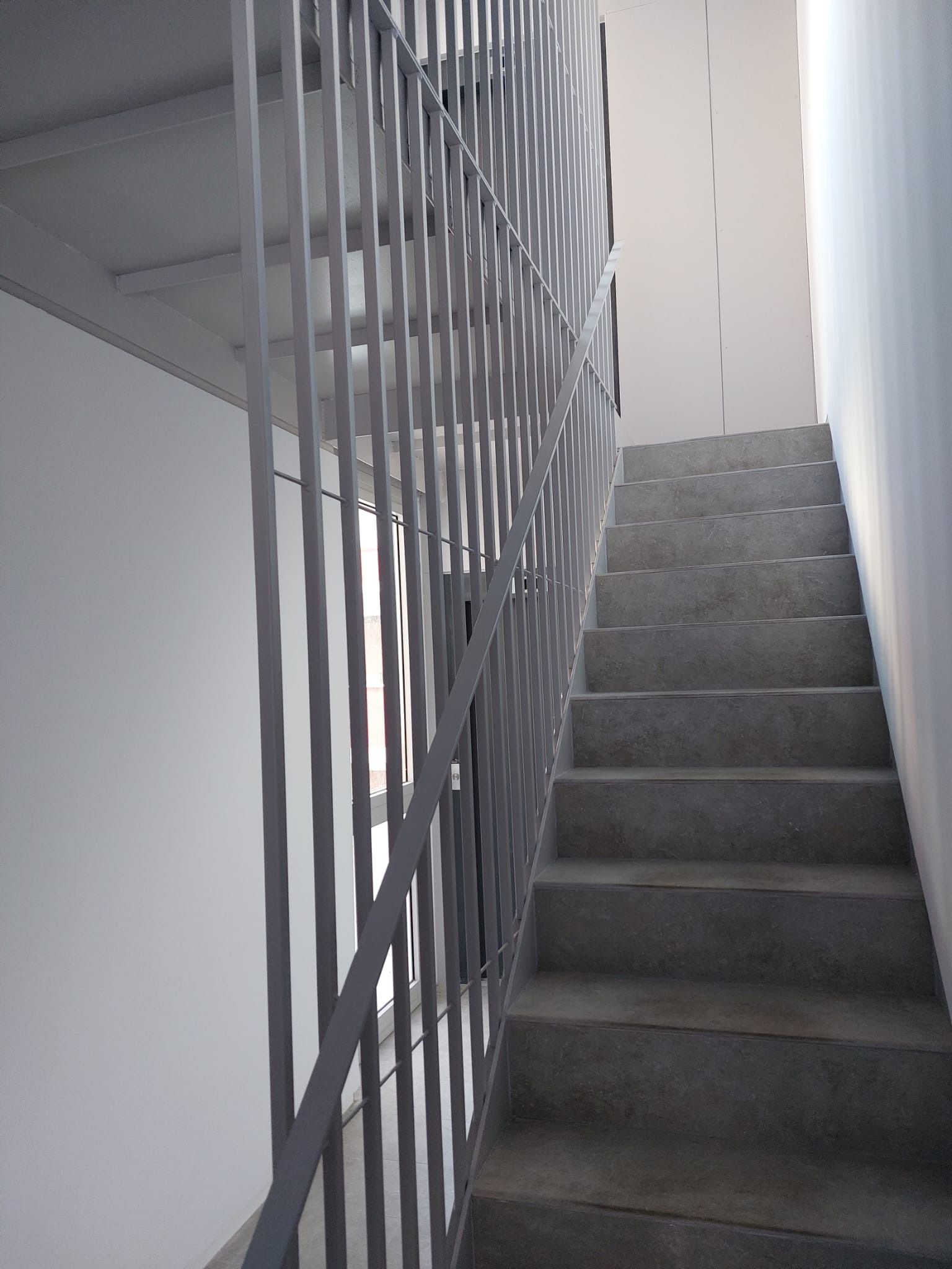 Un conjunto de escaleras con barandilla de metal en un edificio.