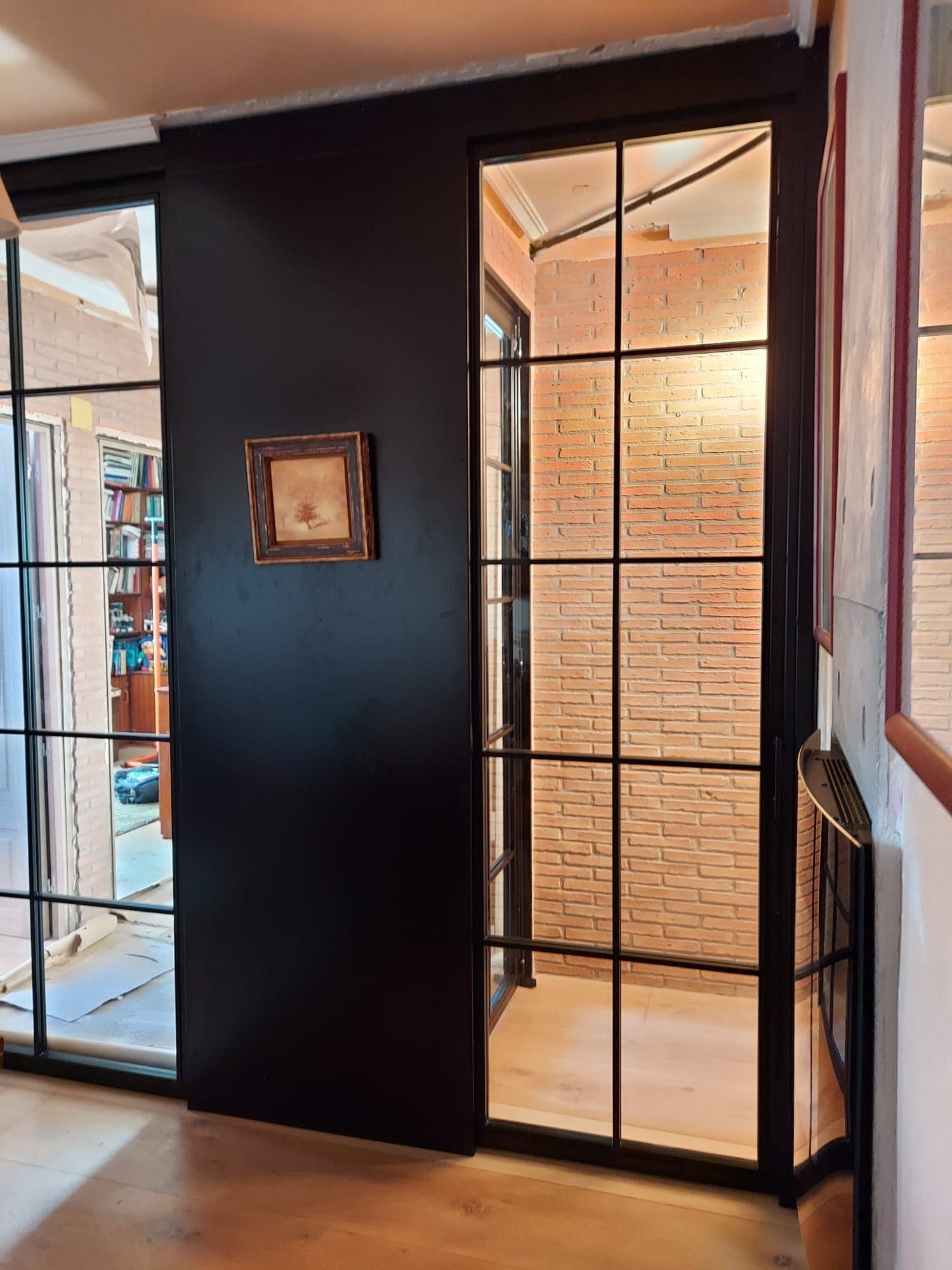 Una habitación con una pared negra y una puerta de cristal.