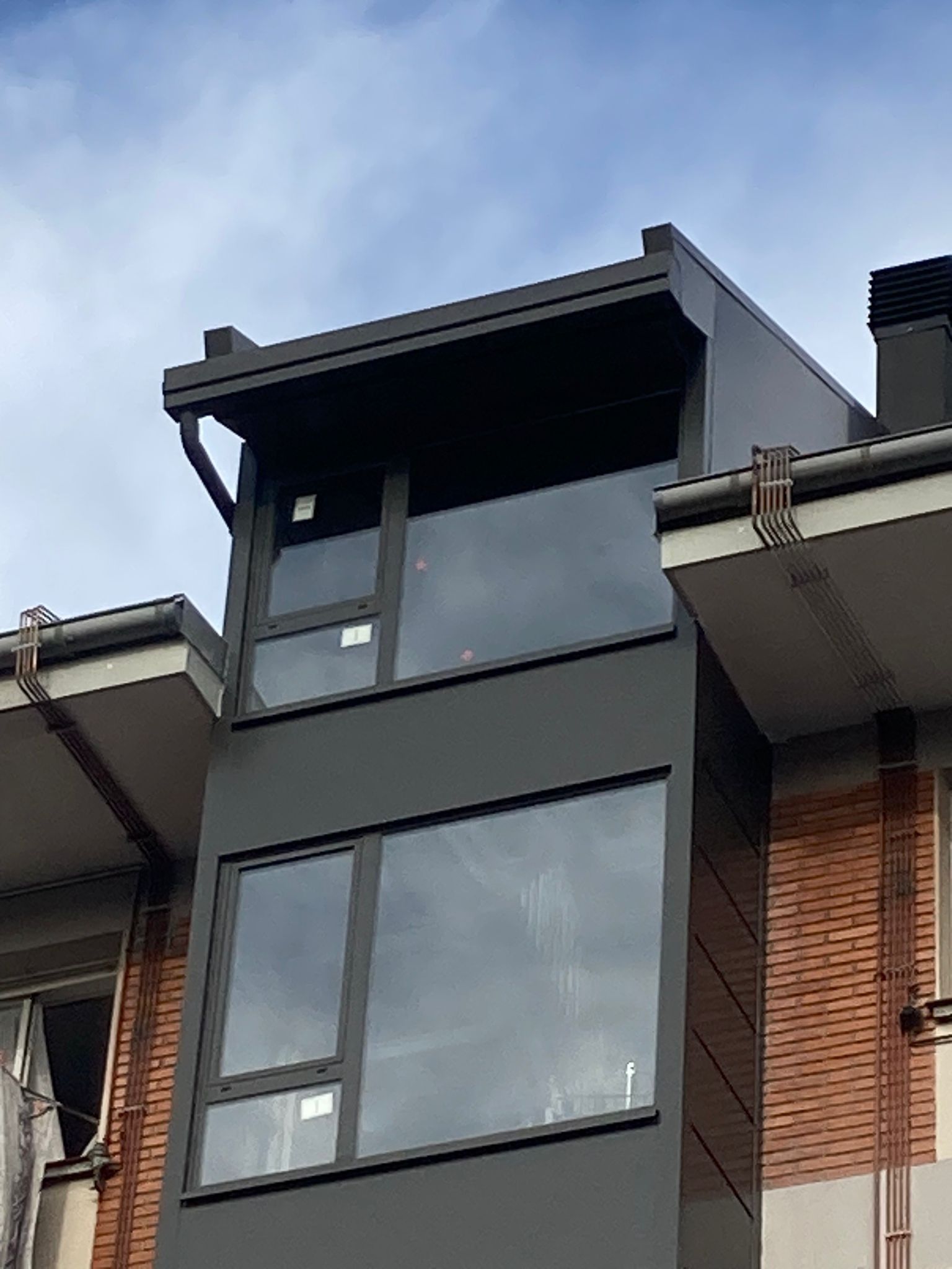 Un edificio con un balcón en la parte superior.