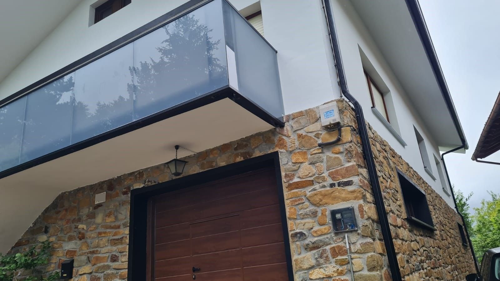 Una casa blanca con un muro de piedra y un balcón.