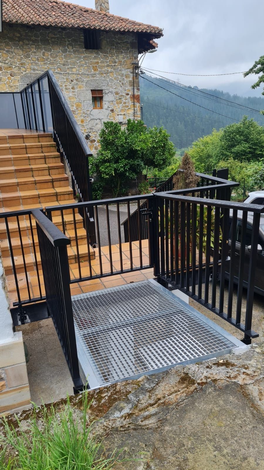 Un conjunto de escaleras que conducen a una casa con una barandilla de metal.