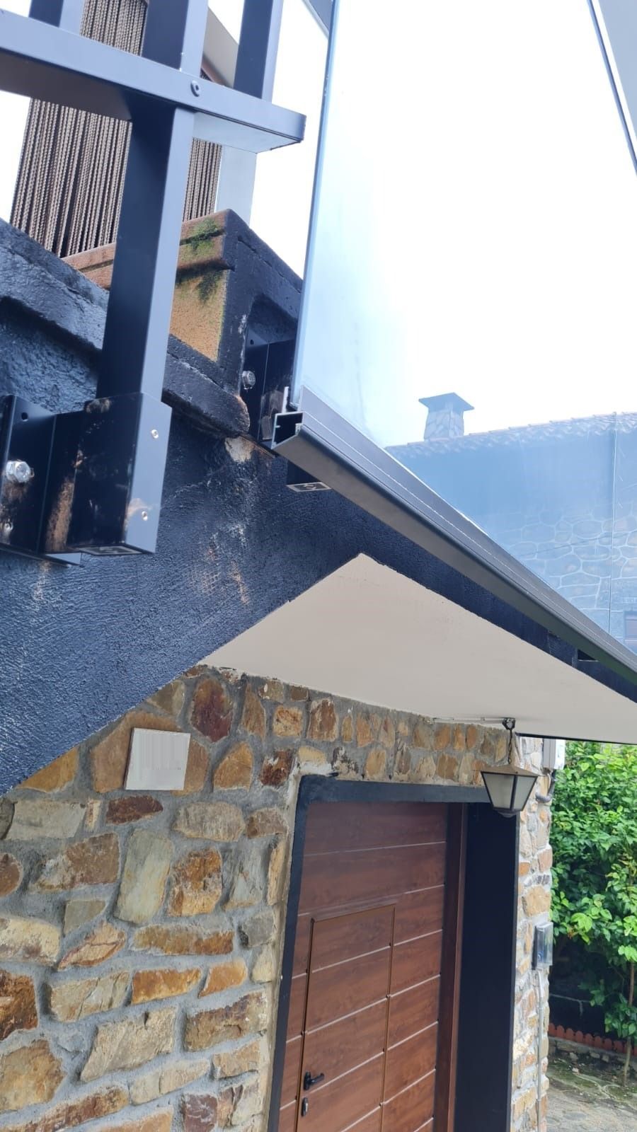 Un edificio de piedra con puerta de garaje de madera y escaleras.