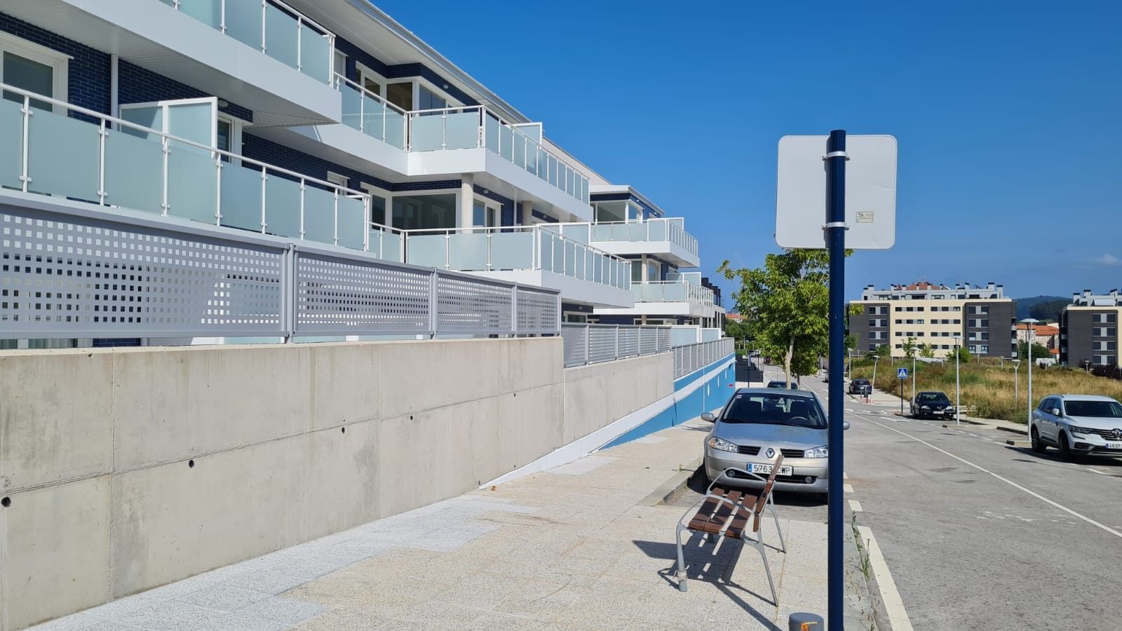 Un coche está aparcado al costado de la carretera frente a un edificio.