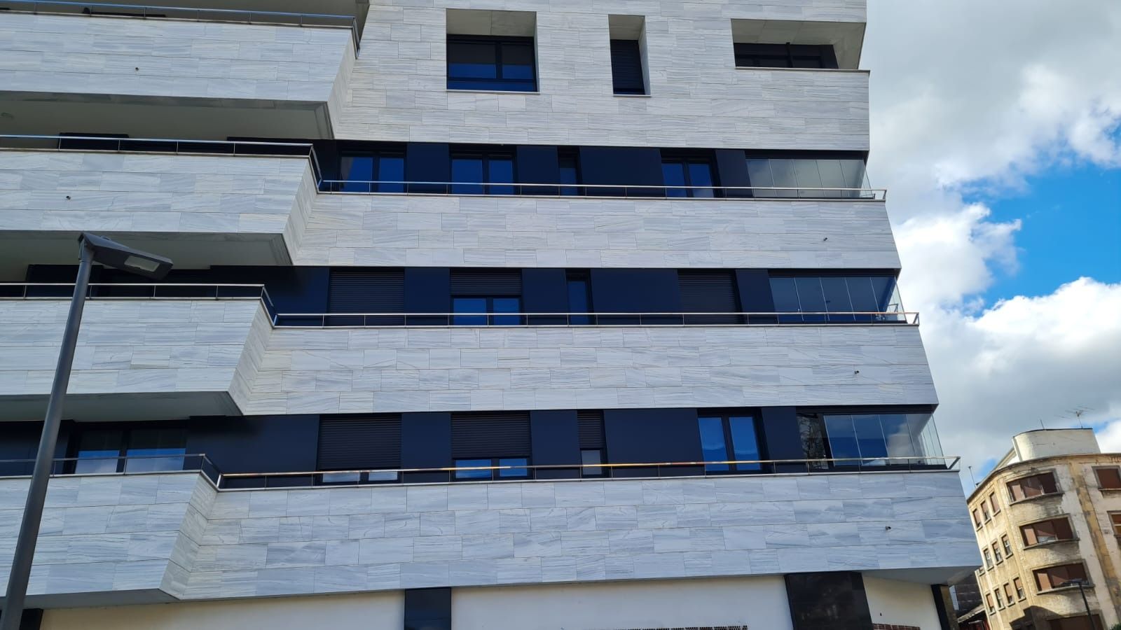 Un edificio blanco con muchas ventanas y balcones.