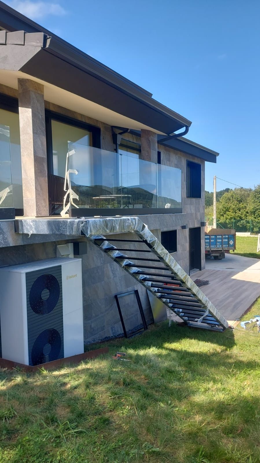 Una casa con escaleras que conducen al segundo piso y un balcón.