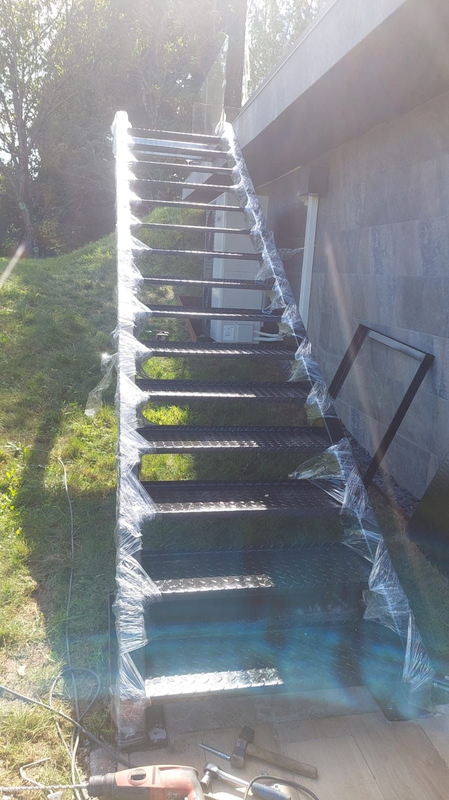 Una escalera está apoyada en el suelo delante de un edificio.