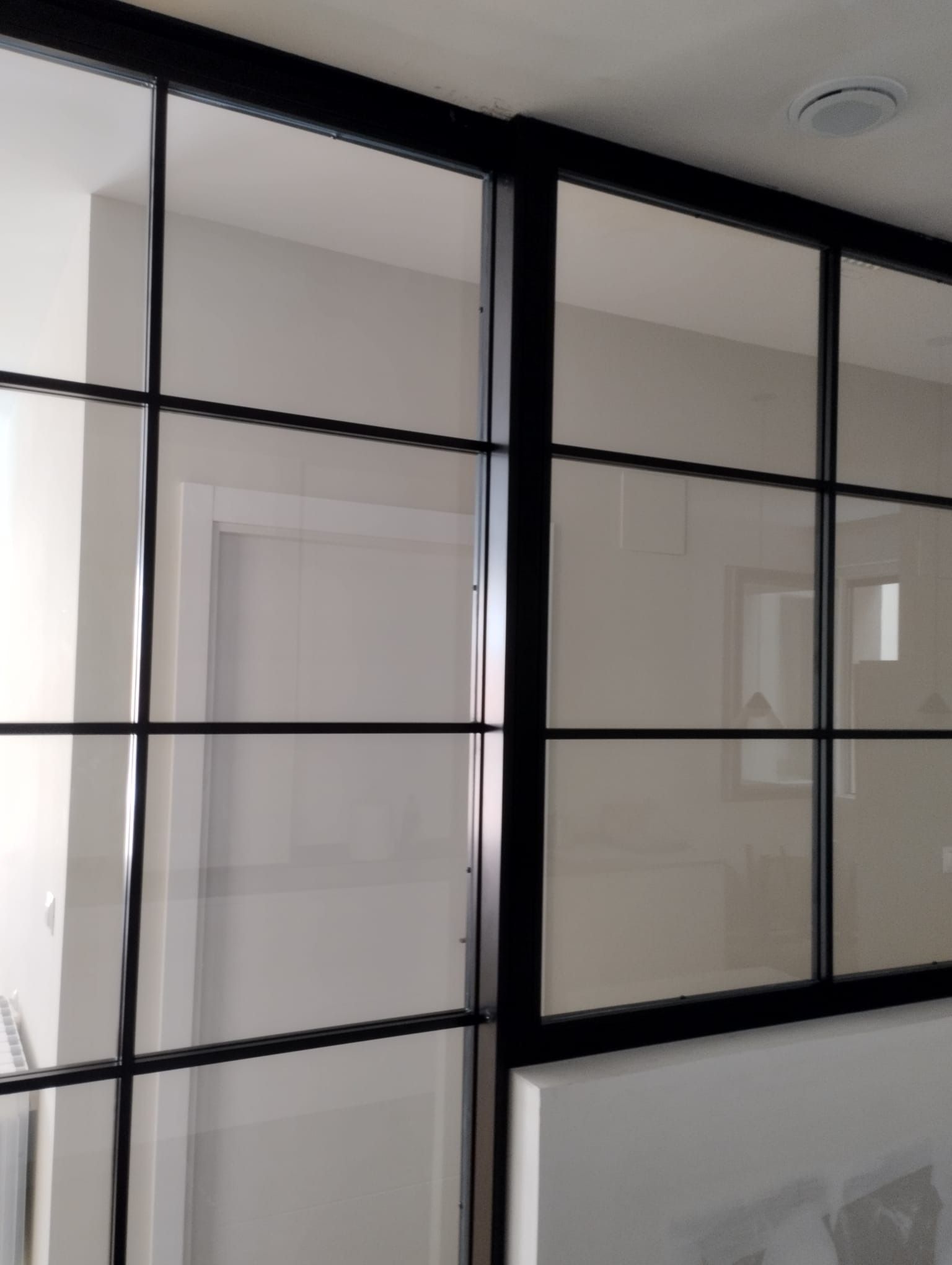 Una habitación con muchas ventanas y un cuadro en la pared.