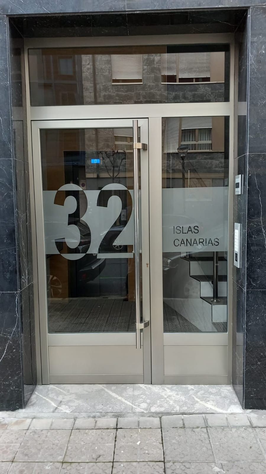 Una puerta de acero inoxidable con el número 32.