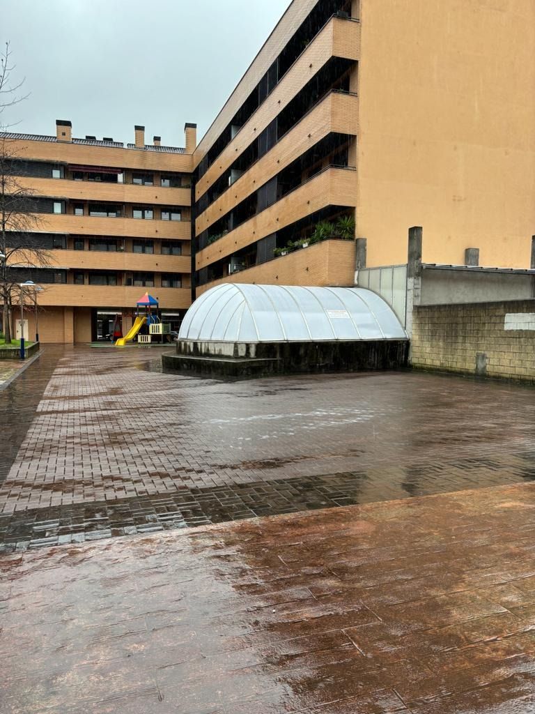 Un gran edificio con un parque infantil enfrente.