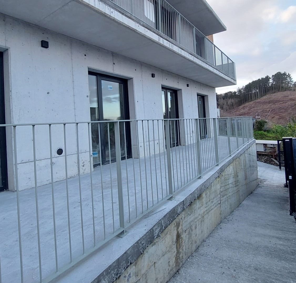 Un edificio con un balcón y una valla alrededor.