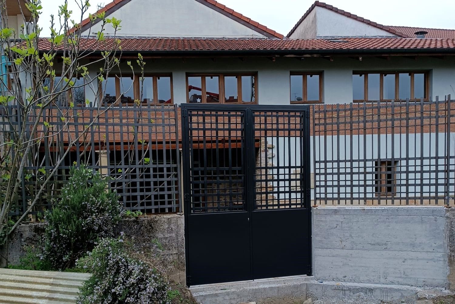 Una casa con una valla y una puerta delante de ella