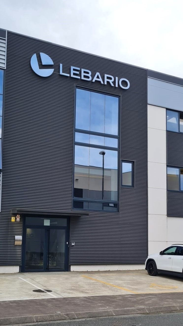 Un edificio grande con un coche aparcado delante.