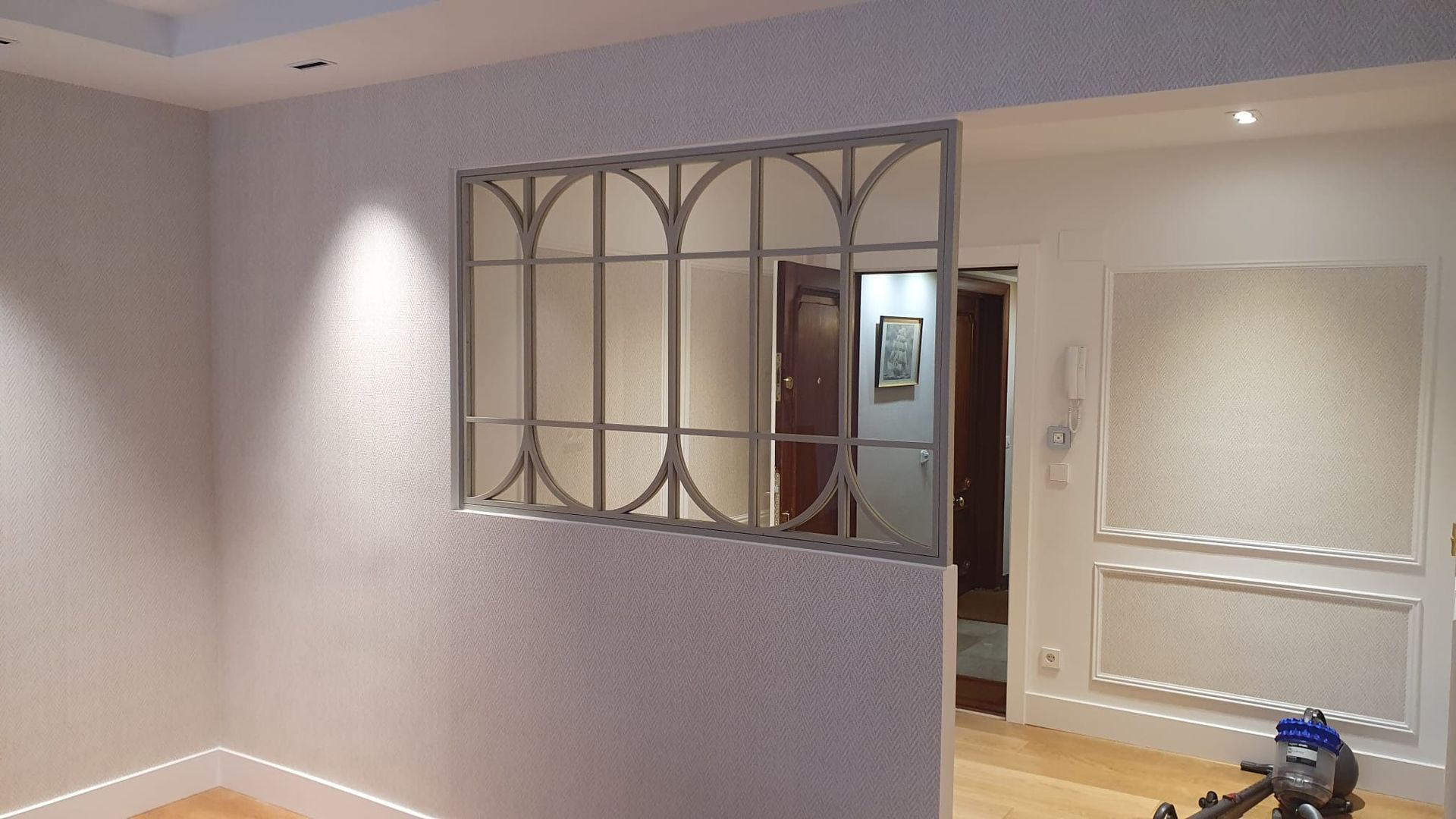 Una habitación con una ventana y un espejo en la pared