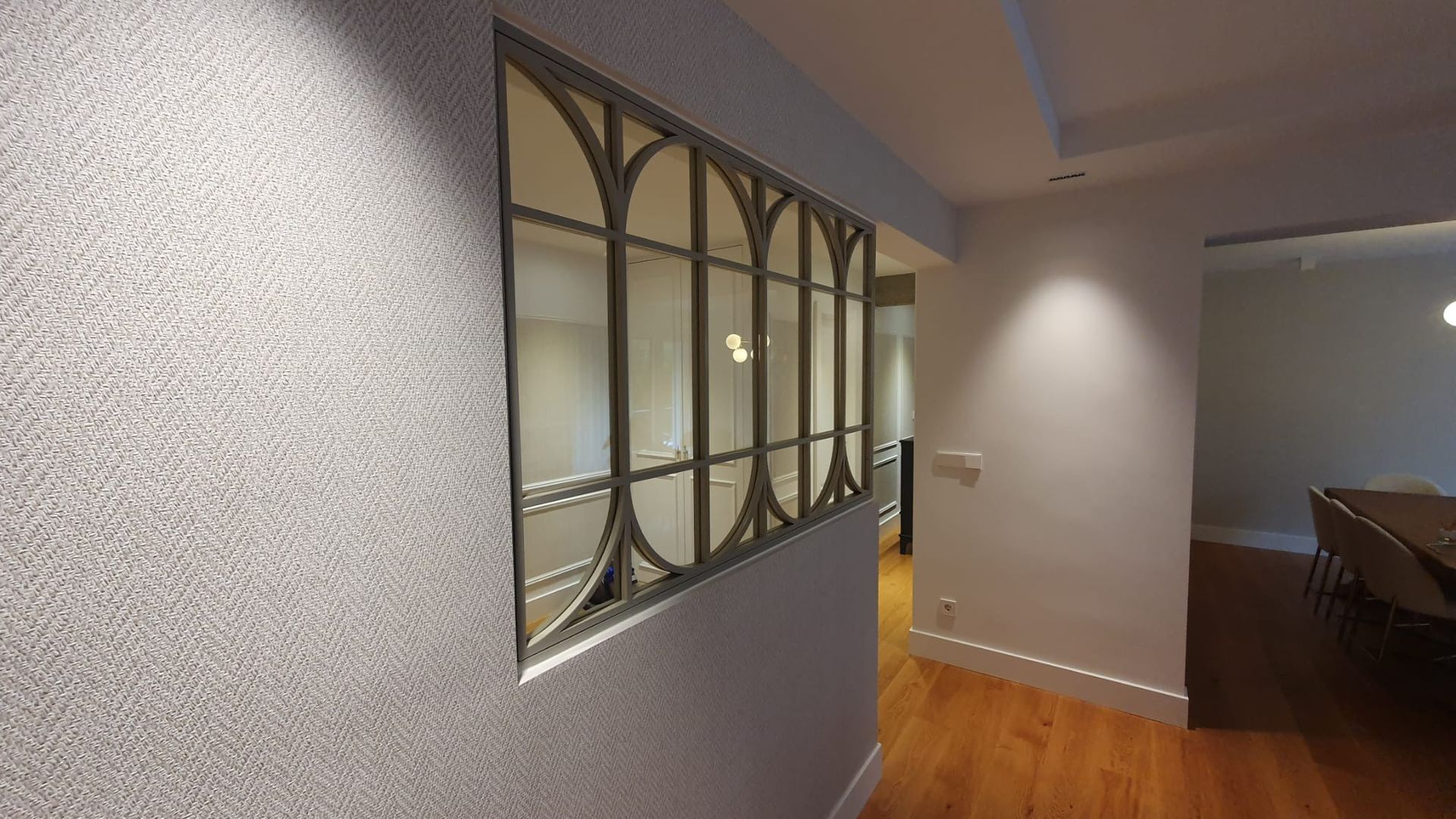 Un pasillo con una ventana en la pared y suelo de madera.