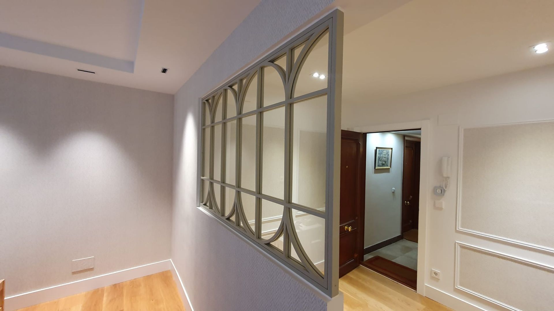 Un pasillo con una ventana entre dos habitaciones de una casa.