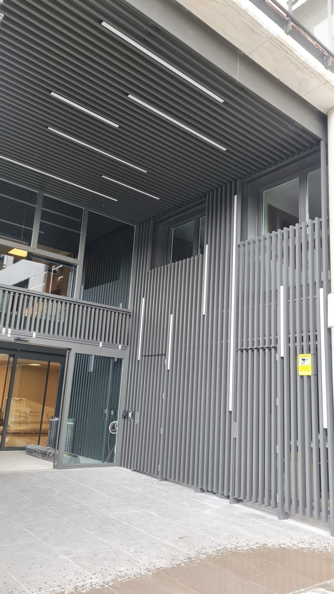 Un edificio grande con una valla alrededor y un balcón.