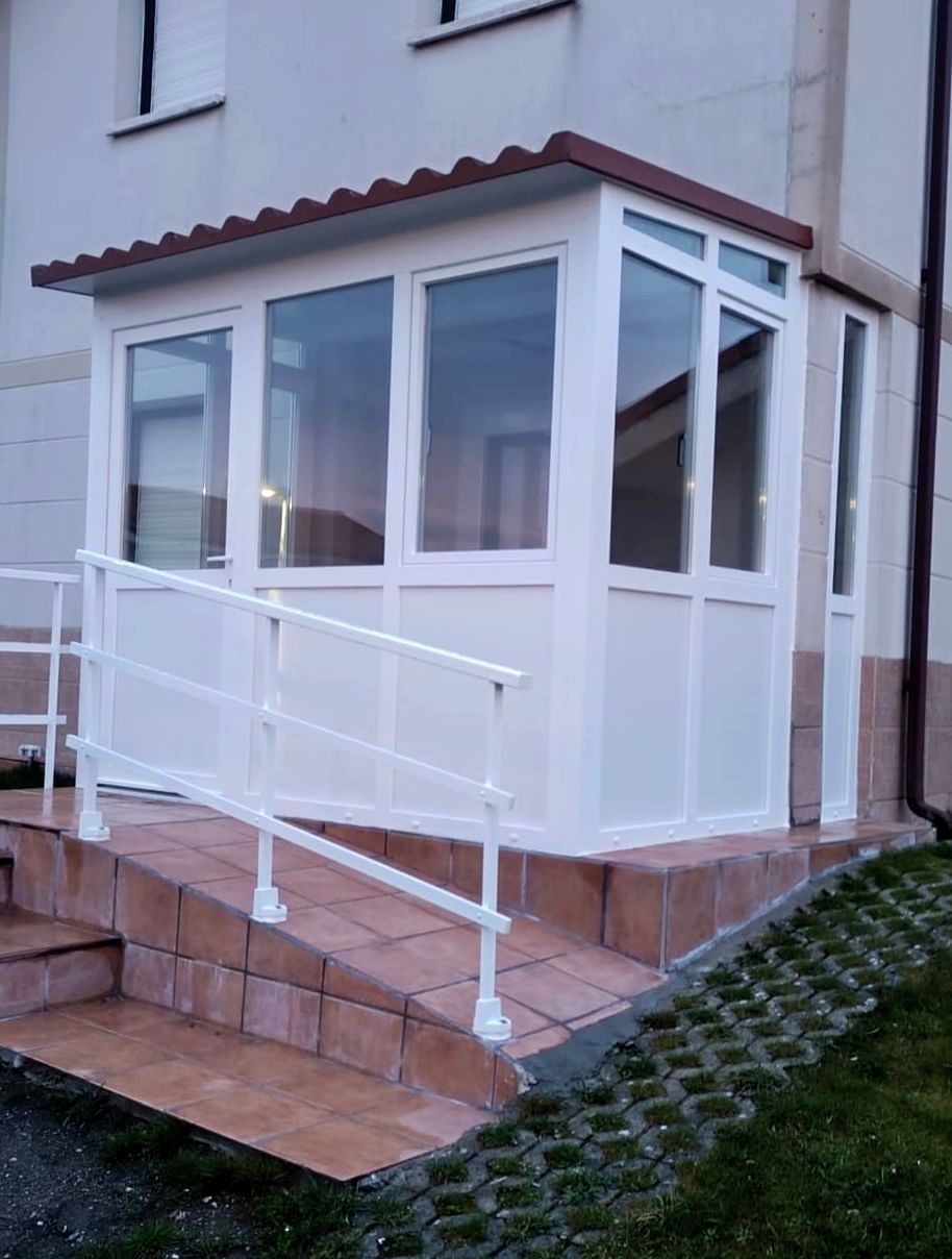 Un porche blanco con una rampa y escaleras que conducen a él.