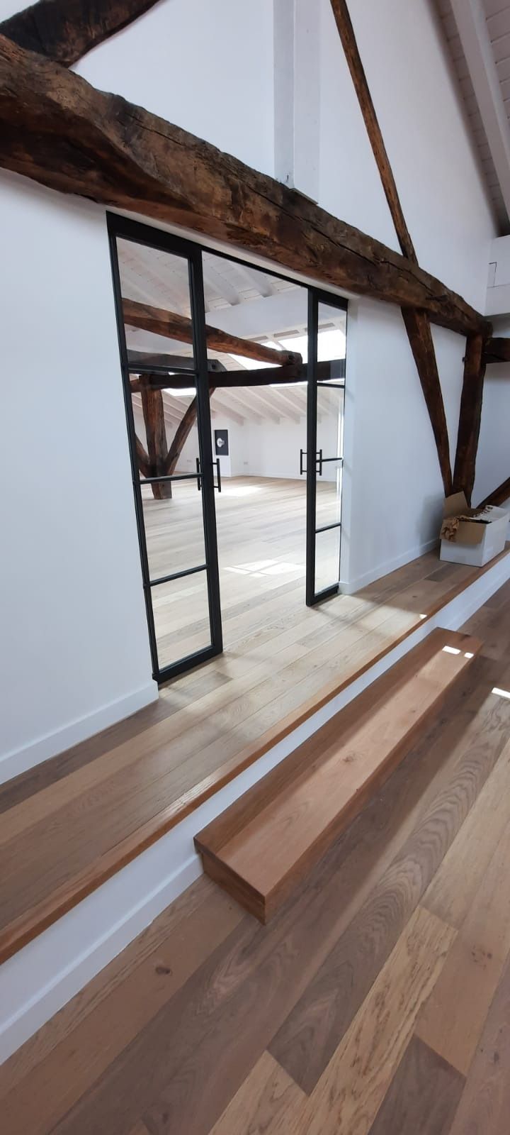 Una habitación con suelo de madera y una puerta corrediza de cristal.