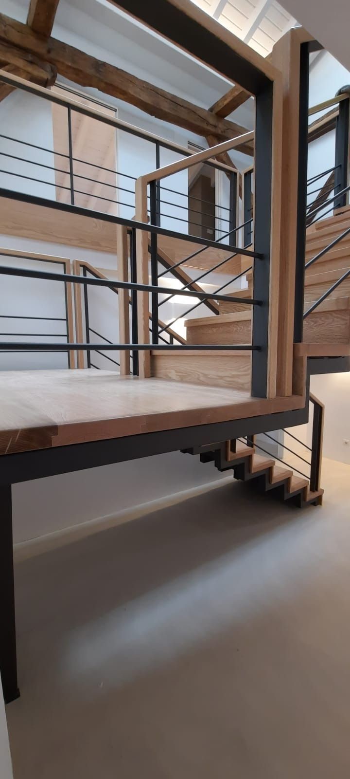 Una escalera de madera con barandilla de metal en un edificio.