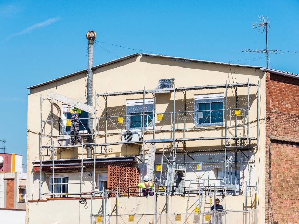 Se está pintando un edificio con andamios a su alrededor.