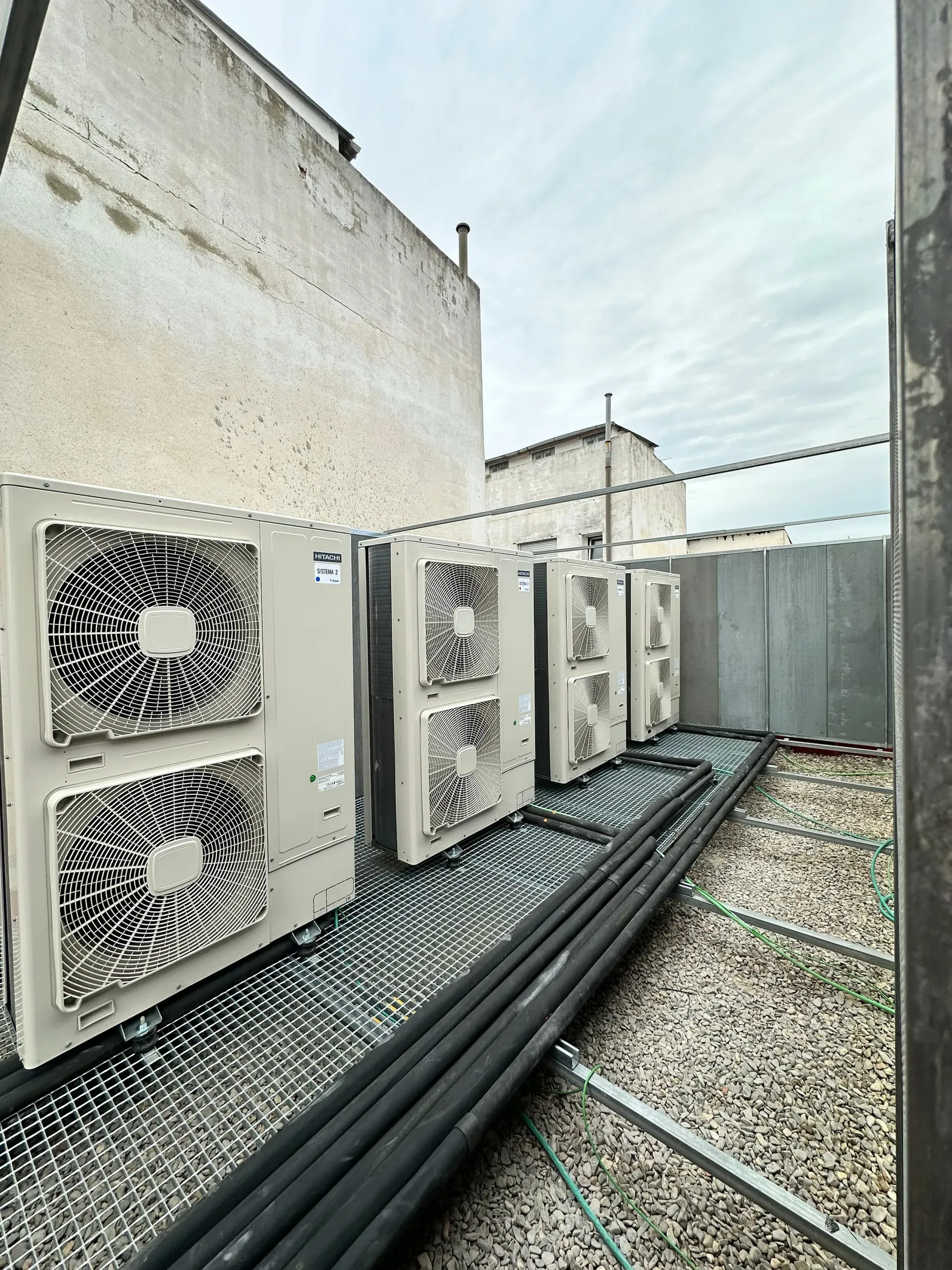 Una fila de aparatos de aire acondicionado están colocados en la parte superior de un edificio.