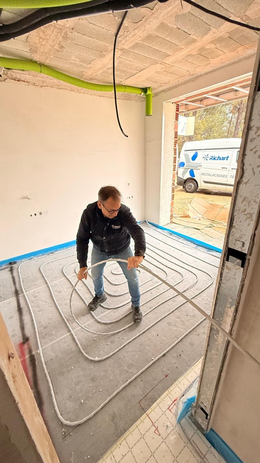 Un hombre está de pie sobre un suelo de baldosas blancas en una habitación.