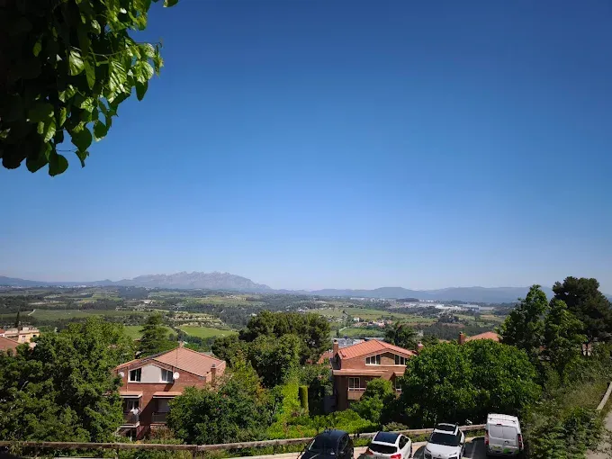 Una vista de una zona residencial con coches aparcados al costado de la carretera.
