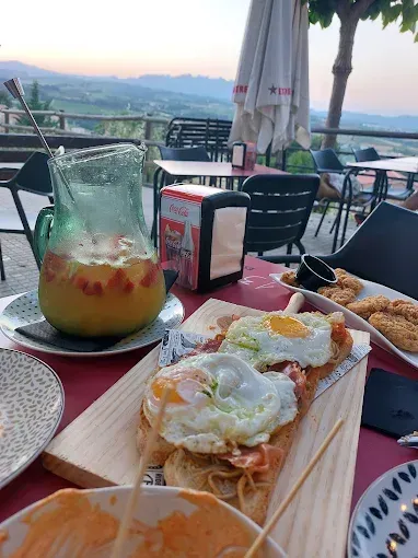 Una mesa cubierta con platos de comida y una jarra de jugo de naranja.