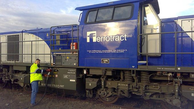 Homme qui remplit la citerne d'un train de carburant