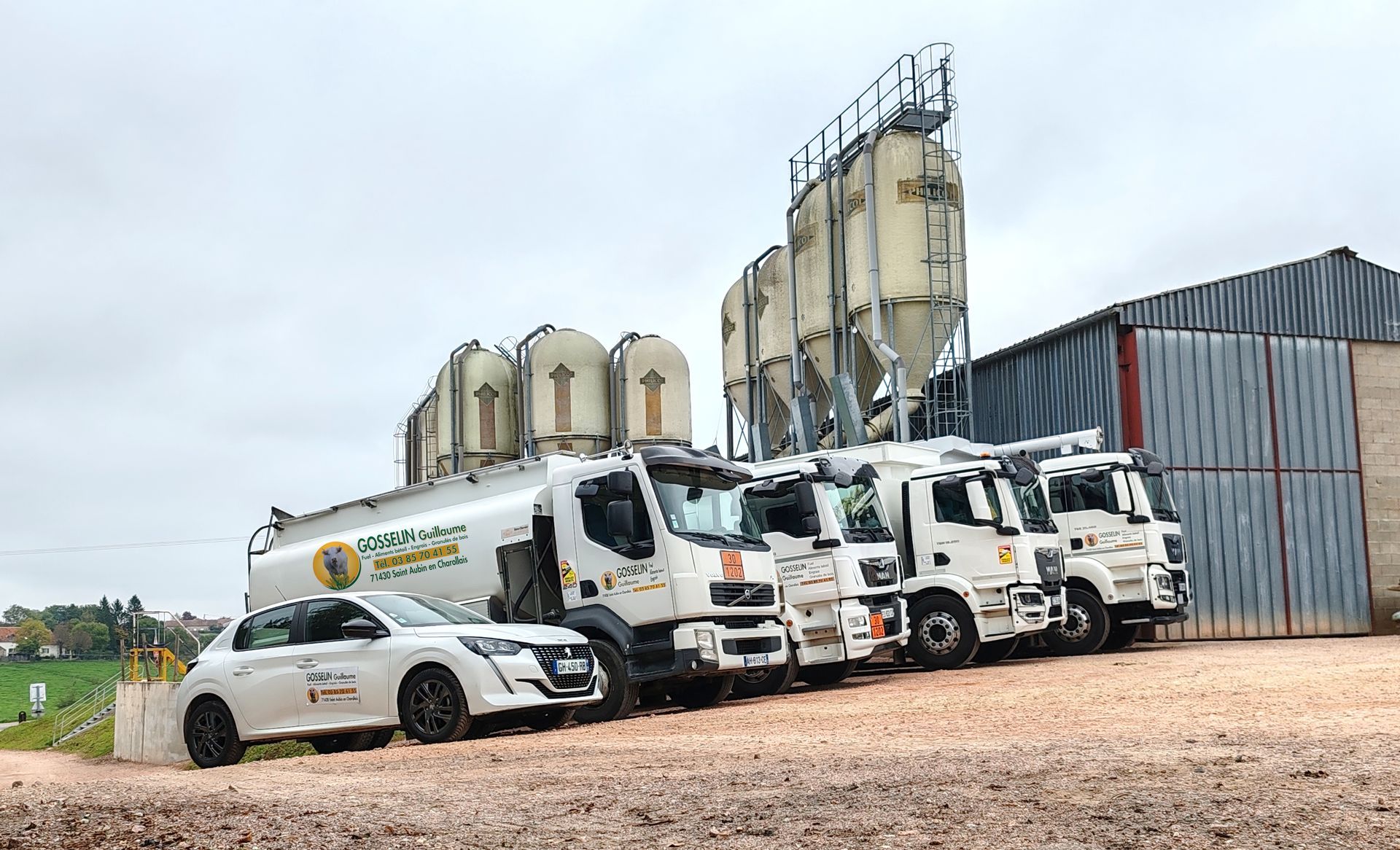 4 hommes en jaunes devant des camions citernes