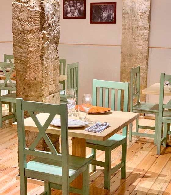 Un restaurante con sillas y mesas verdes con platos.