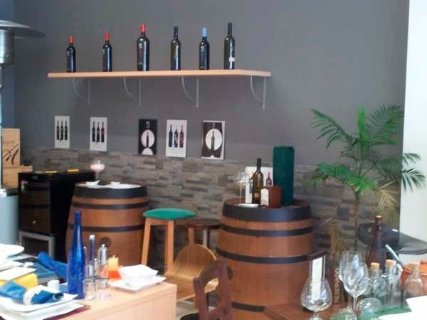 Una fila de botellas de vino en un estante en una habitación.