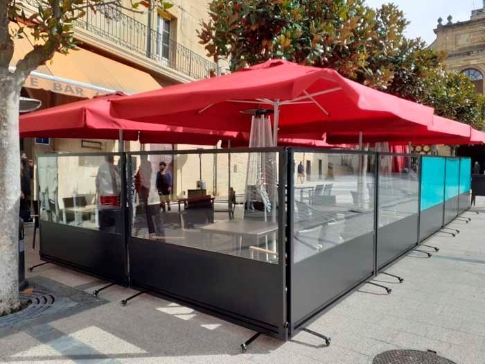 Un restaurante con sombrillas rojas y mesas al aire libre.