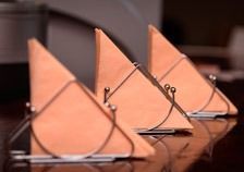 Tres servilletas están colocadas sobre una mesa con forma de veleros.